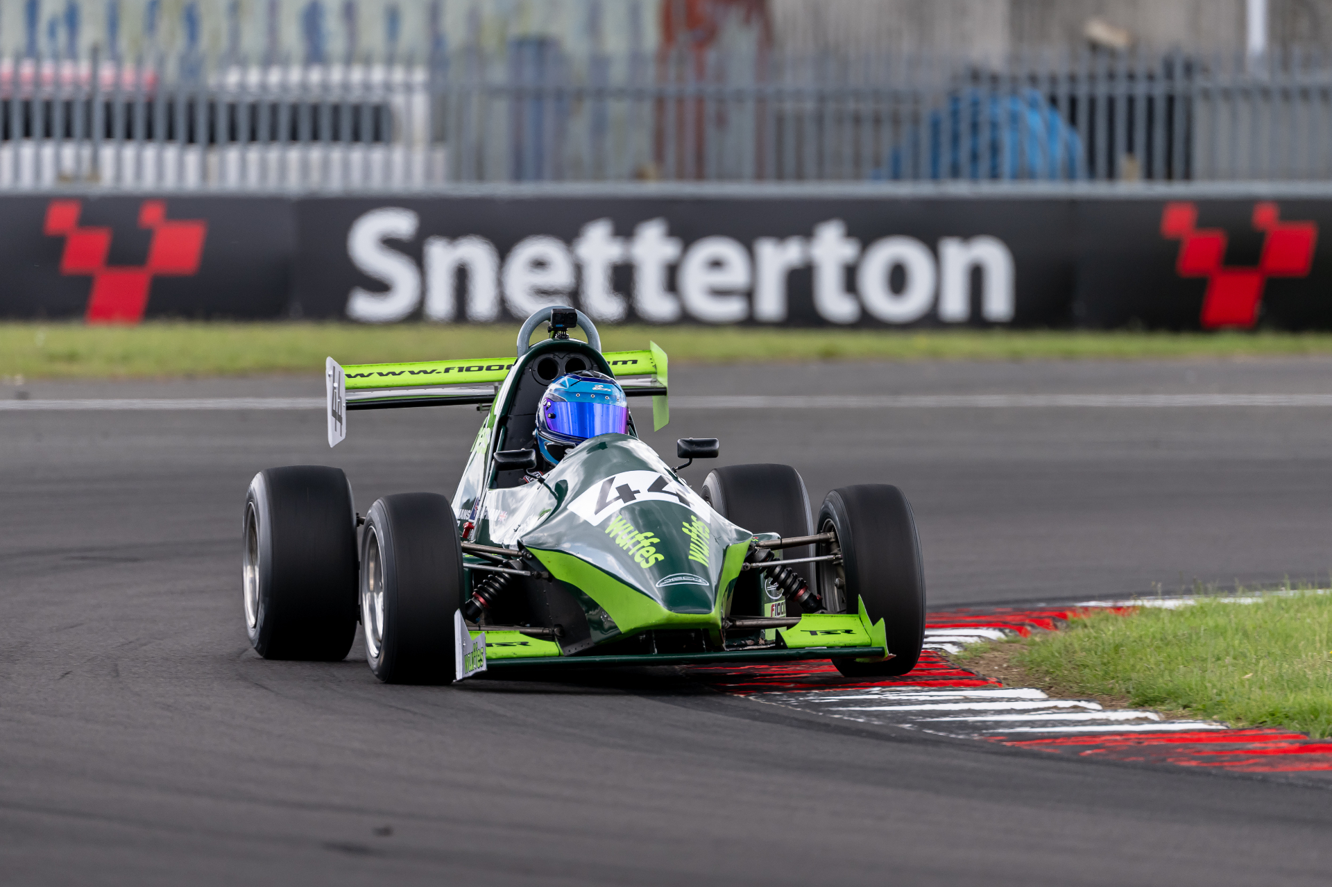 Bert Chapman’s number 44 F1000 taking a kerb at Snetterton